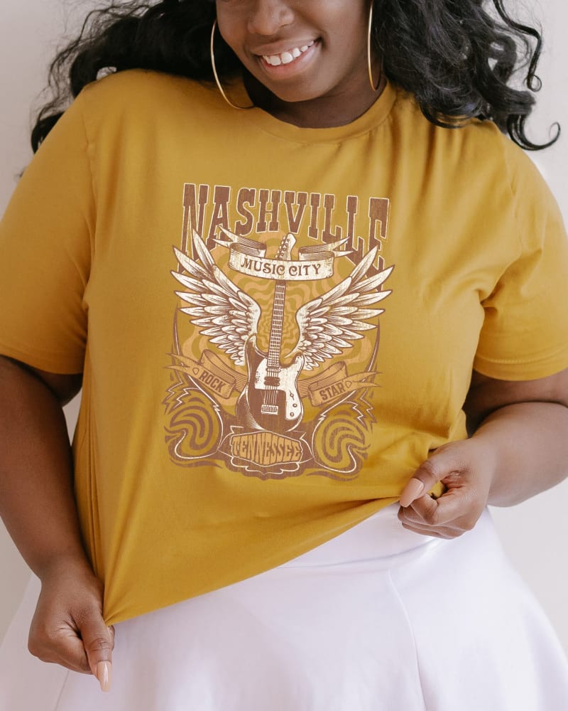 Front of a model wearing a size 2XL Nashville Guitar Wings in Mustard by Simply Sage Market. | dia_product_style_image_id:281572
